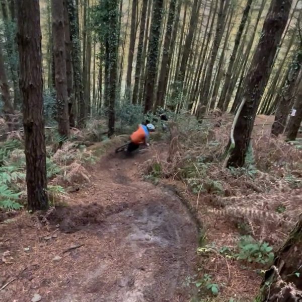 A rider railing a bermed woodland trail at Pontypool